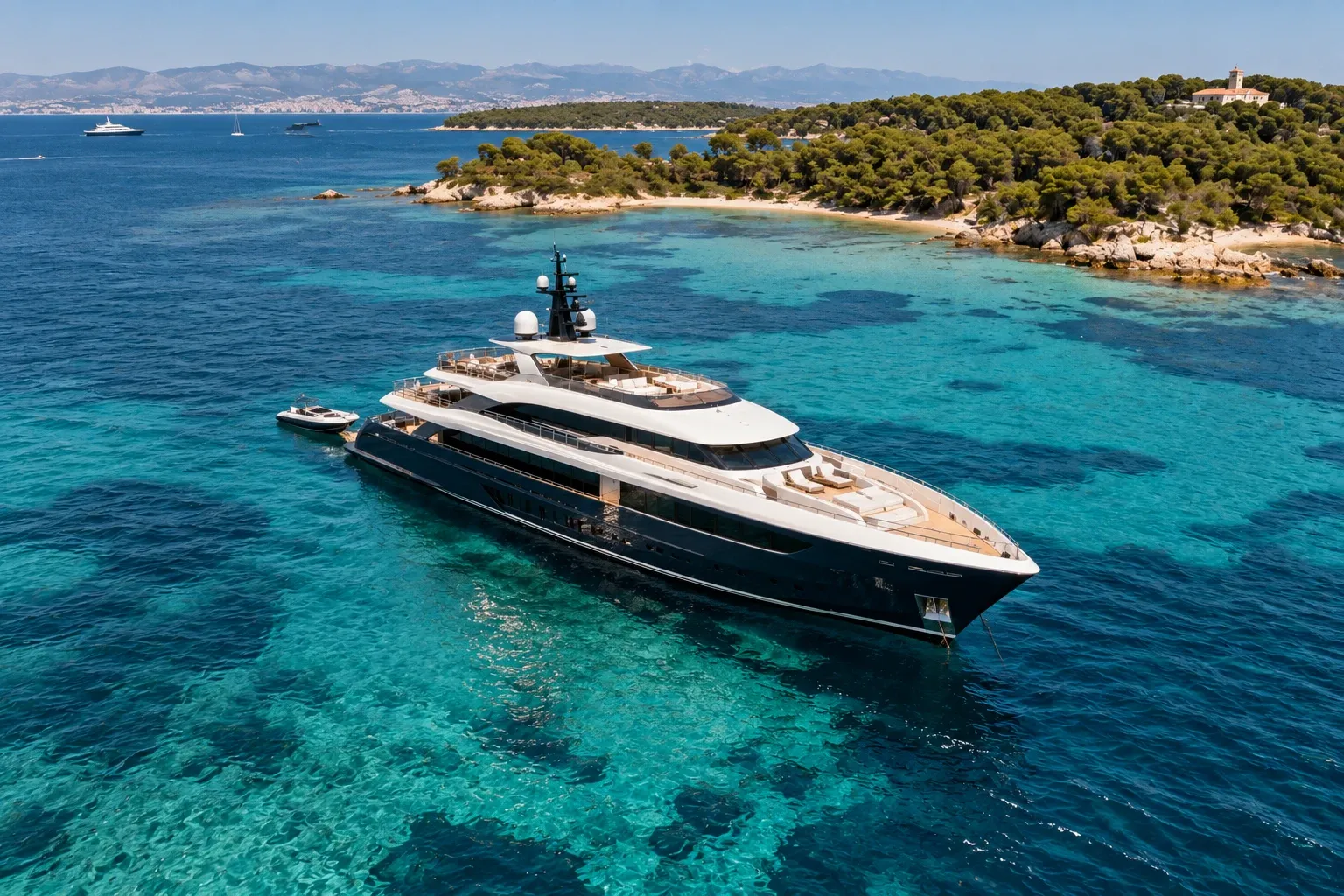 Die Yacht Castellane mit nachtblauem Rumpf, vor Anker im türkisfarbenen Wasser der Lérins-Inseln vor Cannes