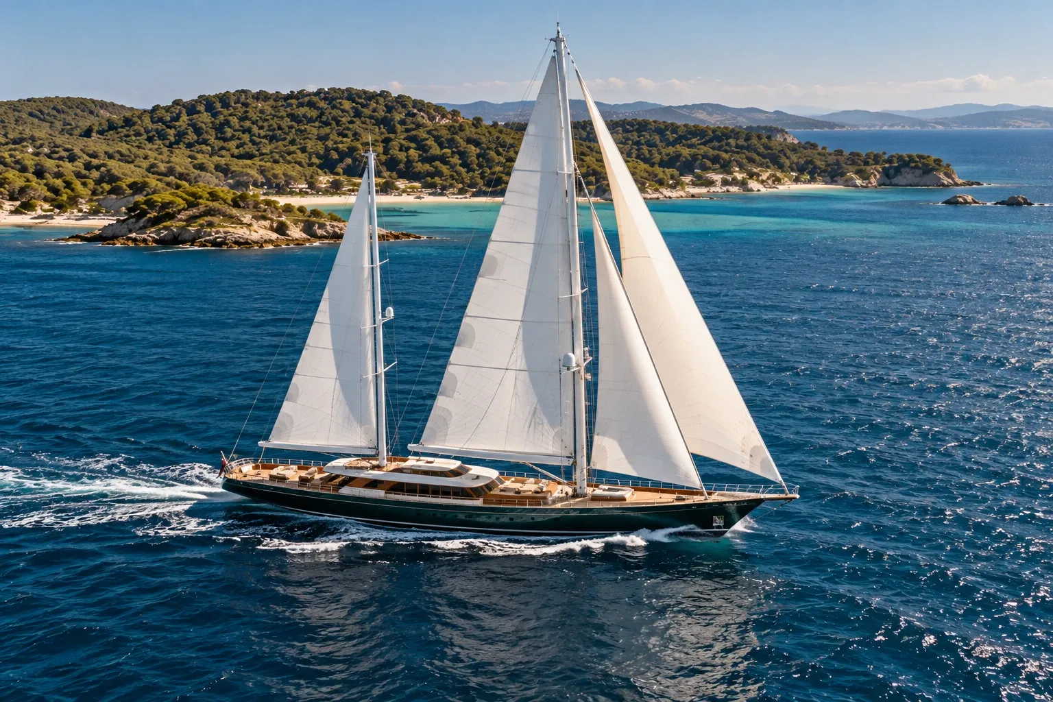 Die Segelyacht Solenne, ein Ketsch mit grünem Rumpf, unter Segeln vor der Insel Porquerolles